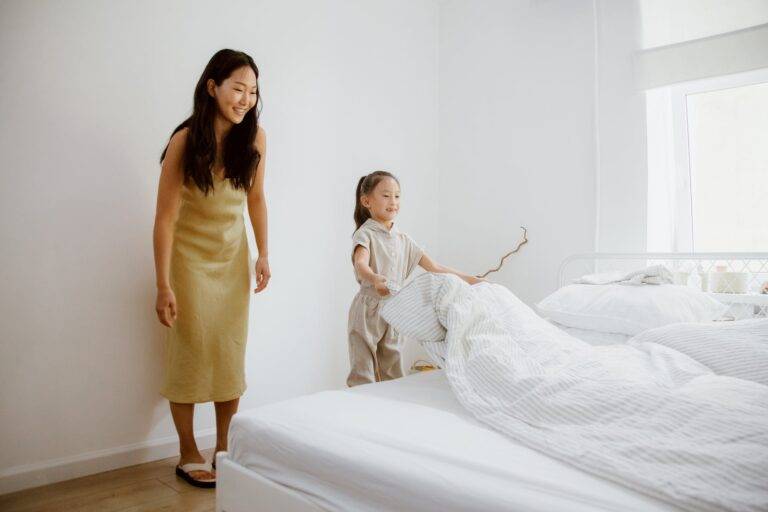 a mother and her child changing the bed sheets